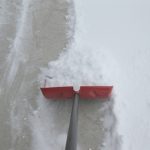 shoveling concrete driveway in winter