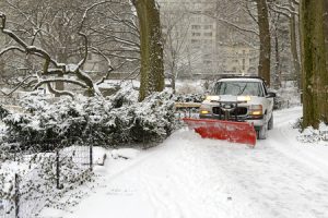 snow plow truck clearing driveway of snow