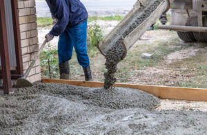 Workers level out the concrete mix at a construction site. Technologies