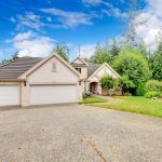 arge beautiful beige and grey house exterior during summer with large driveway