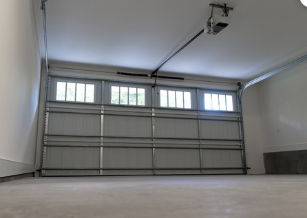 A concrete garage floor with a garage door in the background