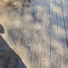 Wooden planks with visible grain, metal fasteners, and shadows cast across the surface.
