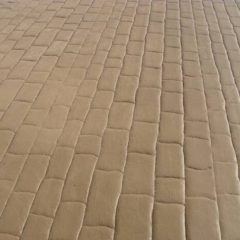 A close-up view of a beige, brick-patterned padded surface.
